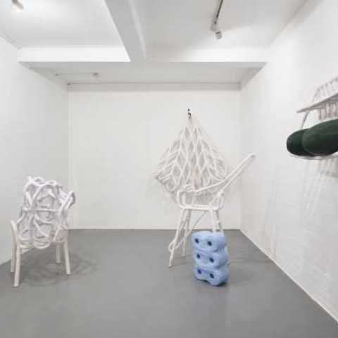 Installation of contemporary shapes, almost tube like sculptures in white, blue and dark green