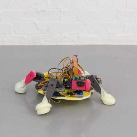 A 'Crawler' (small robot, that walks along the floor capturing videos via a camera on the front, which is projected onto a television screen). Part of Evolutionary Love by Dean Kenning, the Mark Tanner Sculpture Award winner 2020/21.