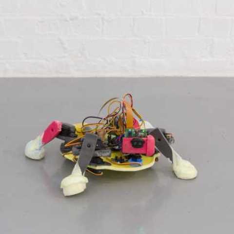 A 'Crawler' (small robot, that walks along the floor capturing videos via a camera on the front, which is projected onto a television screen). Part of Evolutionary Love by Dean Kenning, the Mark Tanner Sculpture Award winner 2020/21.