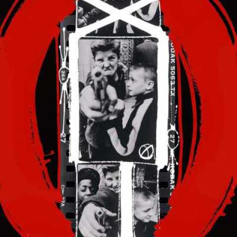 Black and white photograph of young boys playing with toy gun with red and white painting around