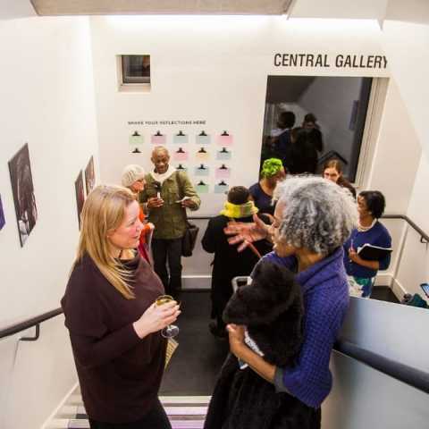 Group of people standing chatting in gallery stairwell